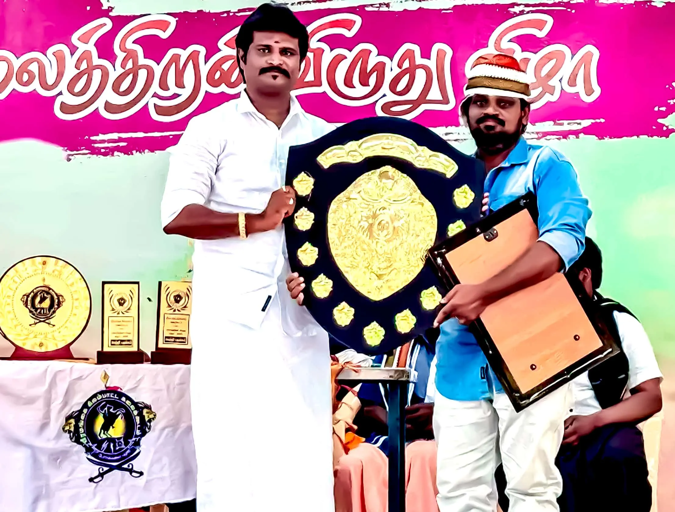 KPN Roofing Shed founder receiving a shield award at a Tamil cultural event